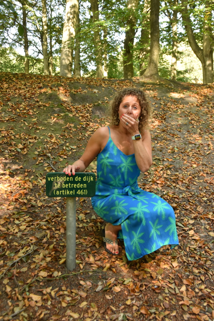Eliza in het bos bij een bordje verboden te betreden. Dit bordje geeft een grens aan. 