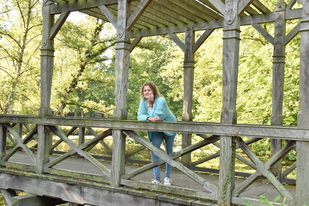 Eliza op een brug in het bos, wat een grens in de natuur. Het verbindt 2 stukken uit het bos met elkaar. 